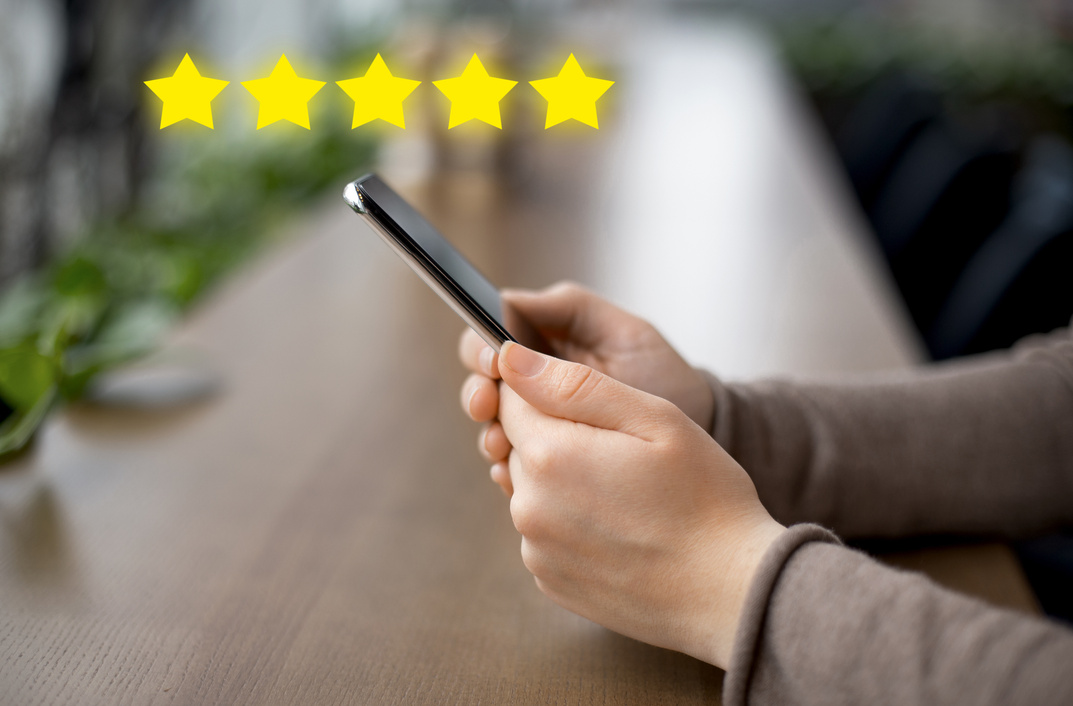 Woman blogger holding cellphone with customer review